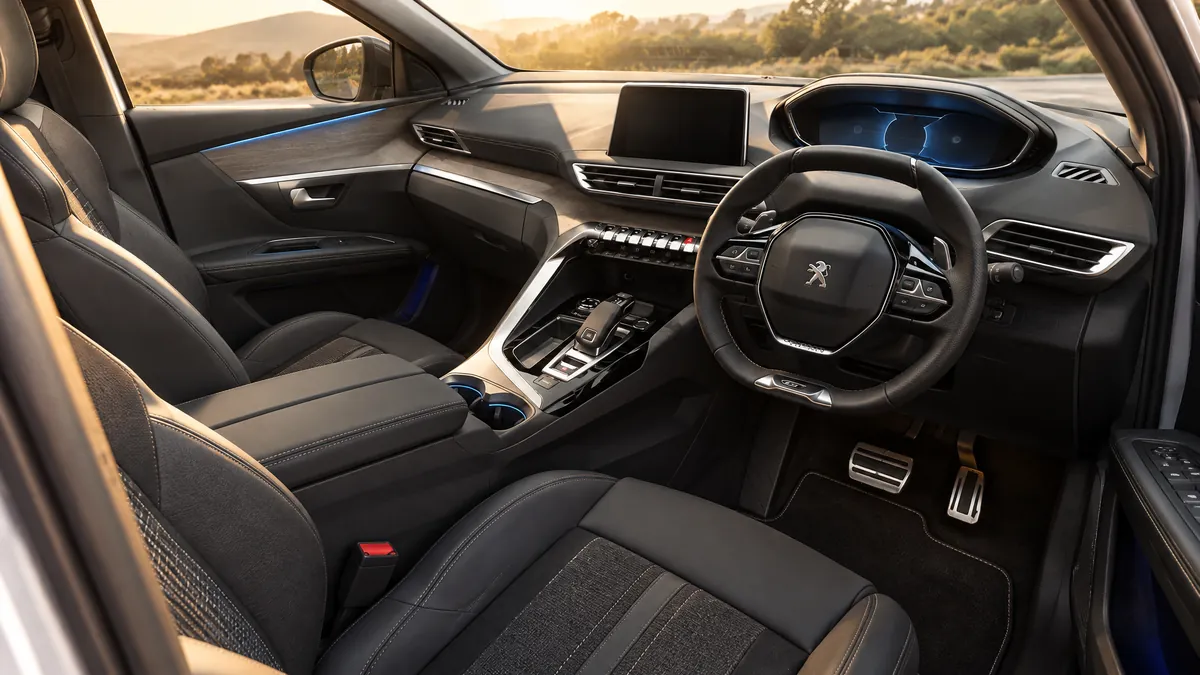 Açık kapıdan Peugeot 5008'in ön koltukları ve i-Cockpit sürücü bölümü